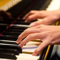 hand of a pianist playing on a piano